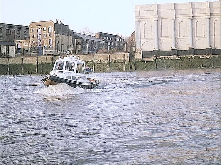 The River Thames with Old Aberdeen Wharf on the right and buildings at the corner of Wapping High Street and Reardon Path to the left. Circa 1981