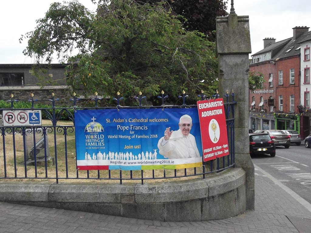 Graveyard railings with a poster showing the Pope.