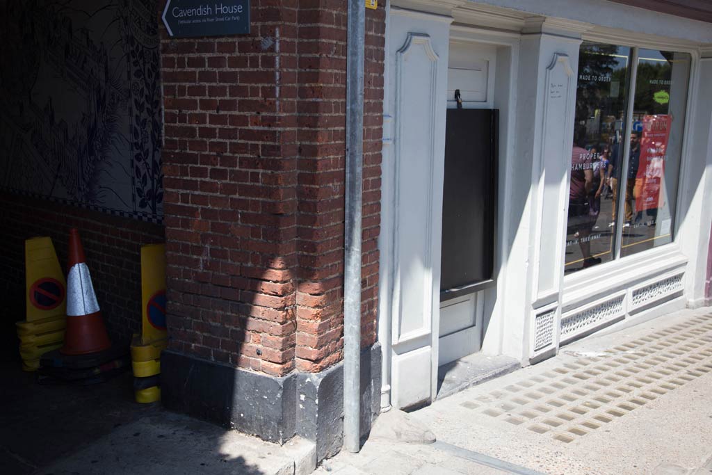 A brick wall and shop entrance on Thames Street, Windsor