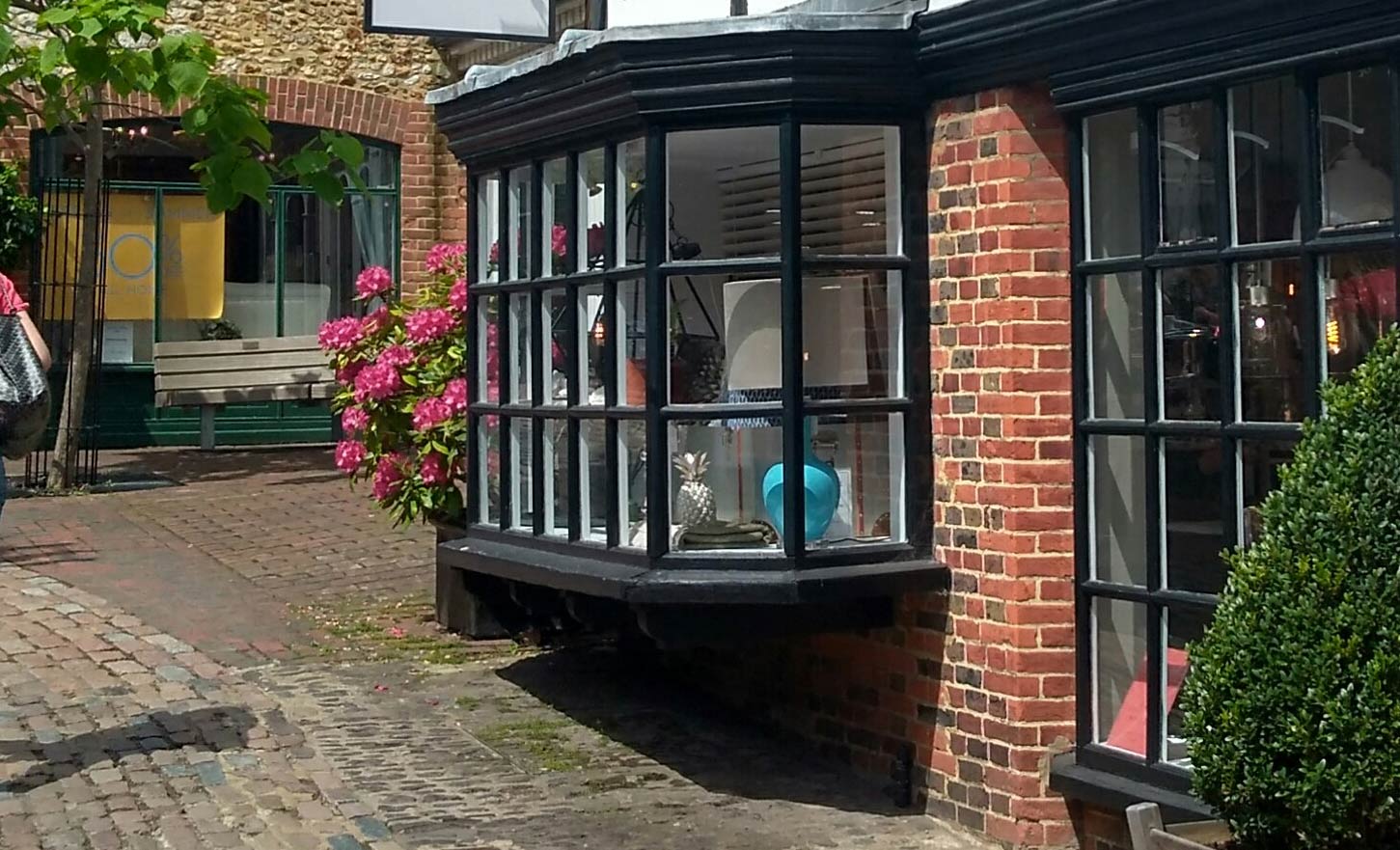 A bow fronted shop frontage in a secluded shopping courtyard.