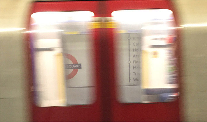 Leicester Square Underground station platform as seen from a train.