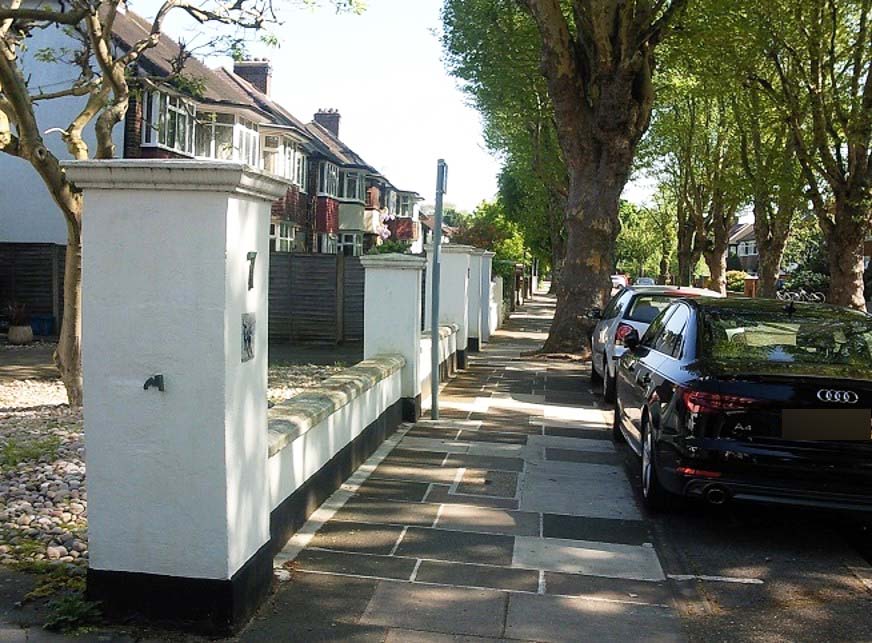 A view along a pavement with the white gate pillar to No7 foremost left.