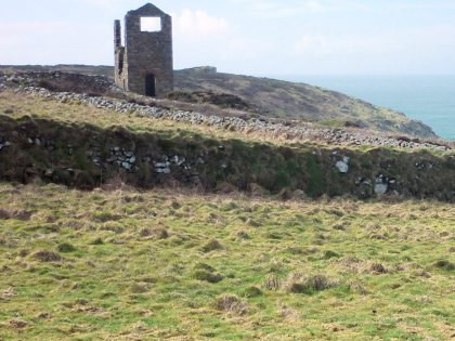 The remains of a Cornish mine engine house on top a cliff top hill.