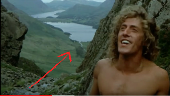 Screen capture showing Tommy between two sheer rock faces and Buttermere beyond.