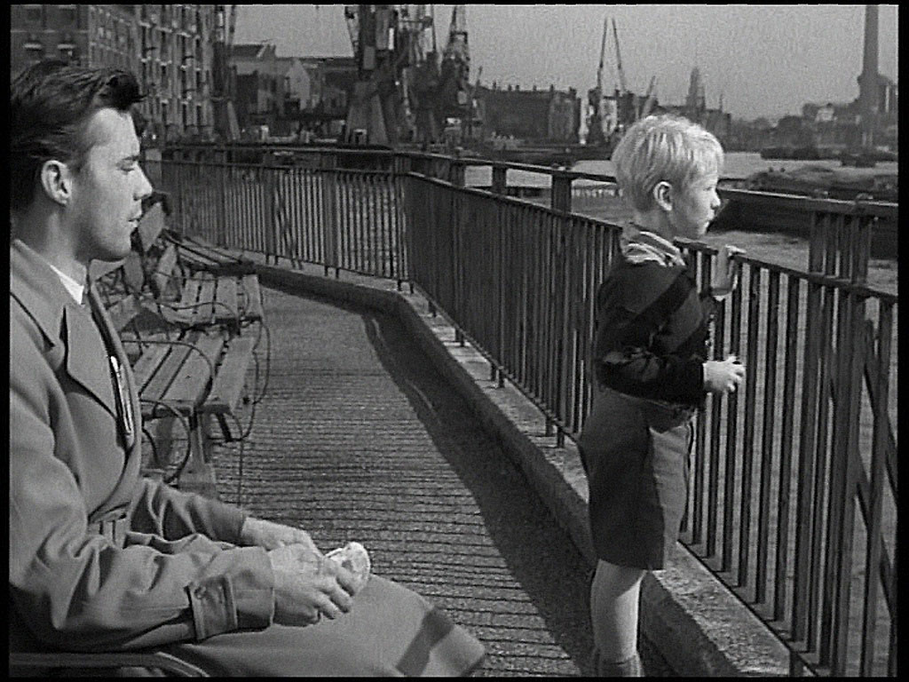 The spire of St. Anne’s Church, Limehouse is showing above Robbie’s head. Circa 1952