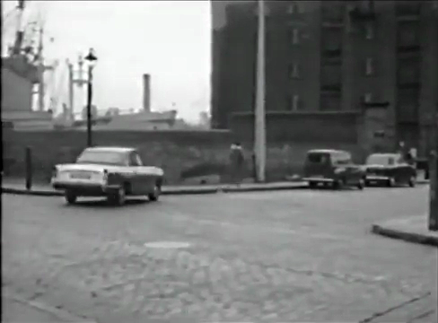Triumph Herald is turning into Garnet Street from the Highway, Wapping, London E1. The ship being mored in Shadwell Basin Circa 1960