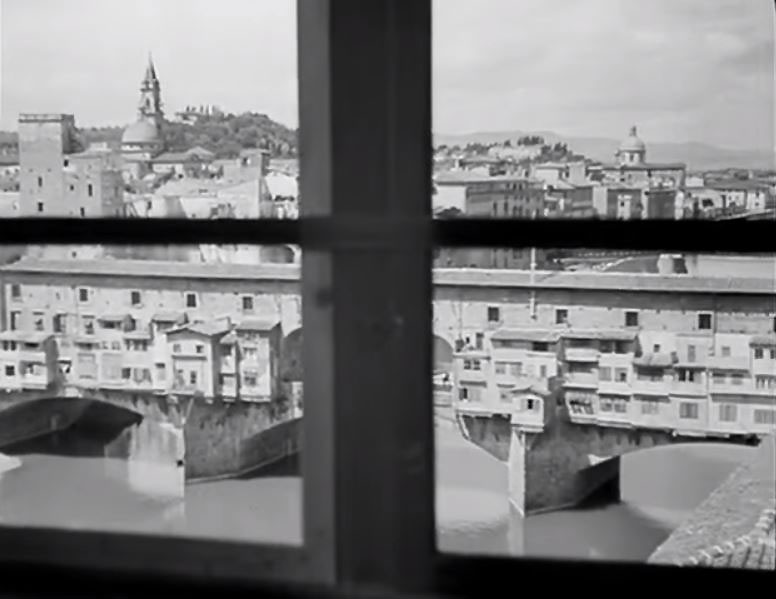 Looking out from second floor of the Uffizi galleries, built between 1335 and 1345, downstream towards the Ponte Vecchio, spanning the Arno. In the left distance the spire of the Basilica del Santo Spirito can be seen, while the dome of San Frediano in Cestello can be seen in the right distance. Circa 1946