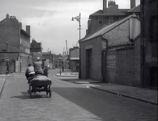 The Highway, E1, here looking east towards the junction with Butchers Row to the left and Narrow Street off to the right, followed by the appearance of Burrell House on the left hand side and Shipwright House opposite. Circa 1957