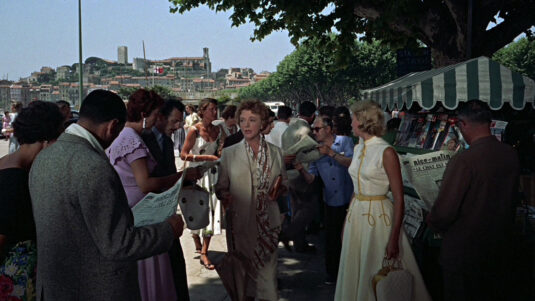 Cannes, the walkway that runs between Bd. de la Croisette and the shoreline, approximately where the Palace of Festivals and Congresses stands with Le Suquet in the background. Circa 1955