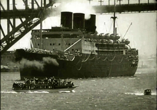 Troop ship passing under the Sydney Harbour Bridge.