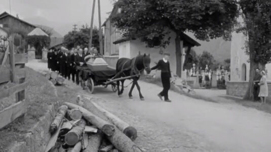 The village of Karres opposite the war memorial chapel, behind it, hidden by the tree, the parish church and to the right the mortuary chapel. Circa 1955